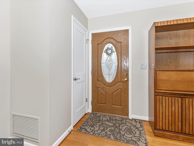 foyer with baseboards, visible vents, and light wood finished floors