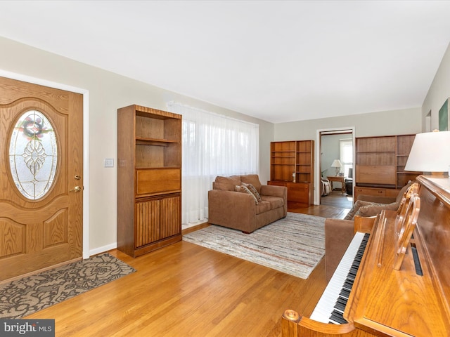 foyer entrance with baseboards and wood finished floors