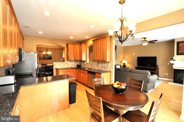 kitchen with arched walkways, stainless steel appliances, a sink, visible vents, and open floor plan