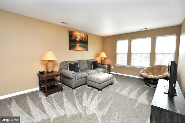 carpeted living area featuring visible vents and baseboards