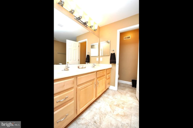 bathroom featuring baseboards, visible vents, vanity, and toilet