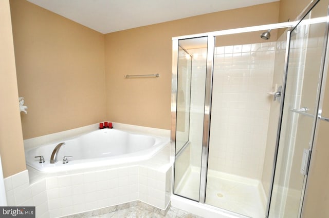 bathroom featuring a shower stall and a bath