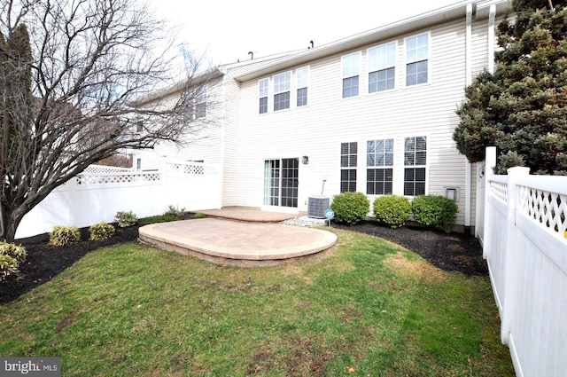 rear view of property with fence private yard, a patio area, and a yard