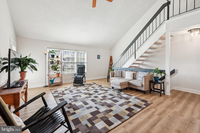 living area with a textured ceiling, wood finished floors, and baseboards