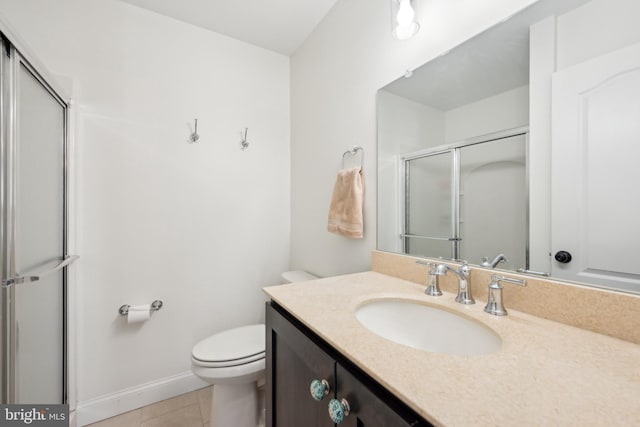 bathroom featuring toilet, vanity, baseboards, tile patterned floors, and a shower with door