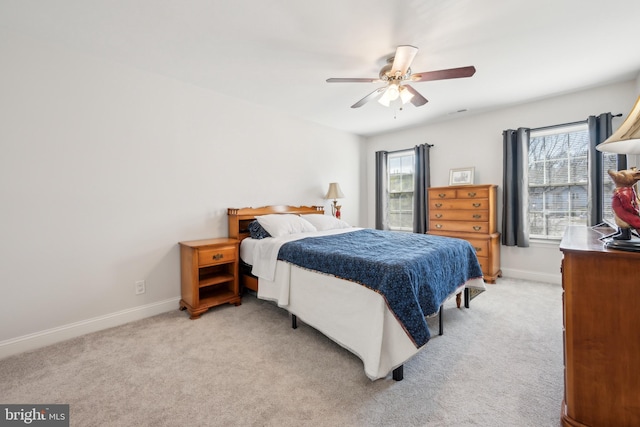 bedroom featuring baseboards, a ceiling fan, and light colored carpet