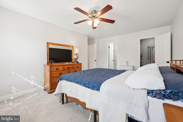 carpeted bedroom with ceiling fan and baseboards