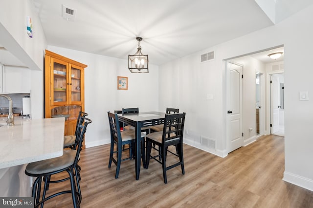 dining space featuring visible vents and light wood-style flooring