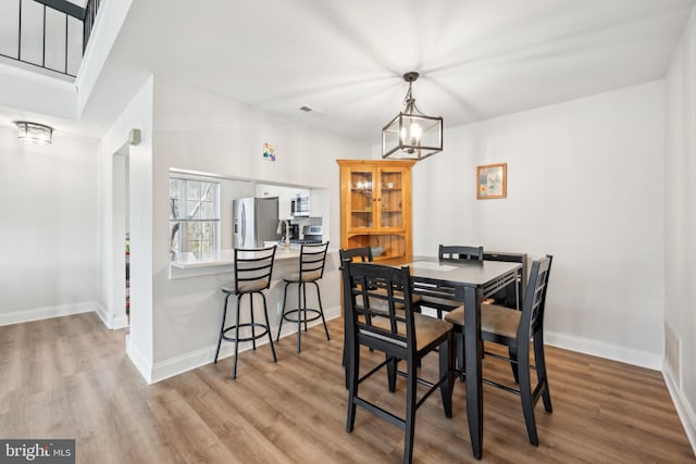 dining room featuring an inviting chandelier, baseboards, and wood finished floors