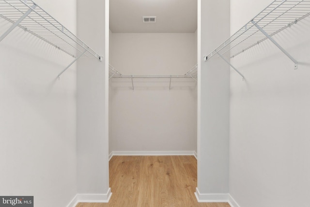 walk in closet featuring visible vents and wood finished floors