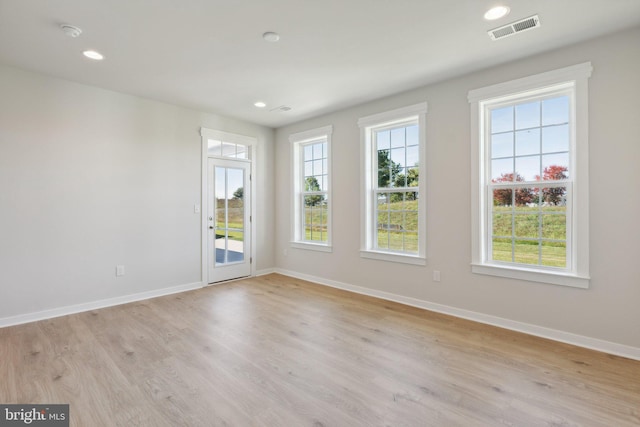 spare room featuring baseboards, visible vents, light wood-style flooring, and recessed lighting