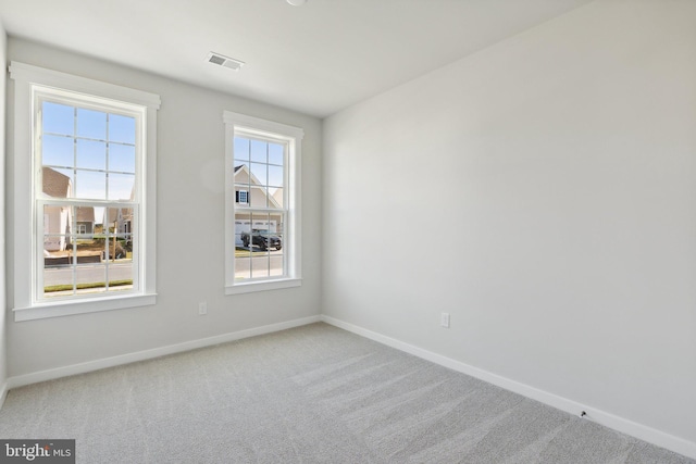 carpeted spare room with baseboards and visible vents