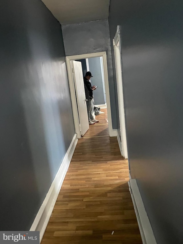 hall featuring wood finished floors and baseboards