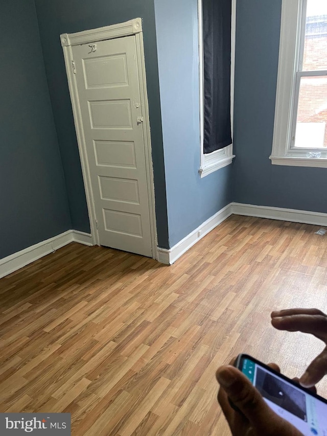 empty room with baseboards and wood finished floors