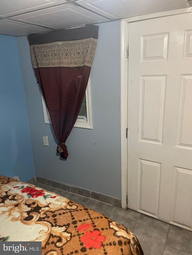 bedroom with baseboards and tile patterned floors