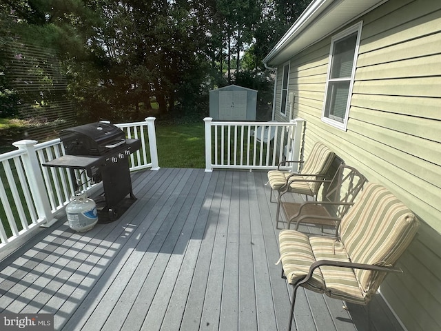 wooden deck with a storage unit, area for grilling, and an outbuilding