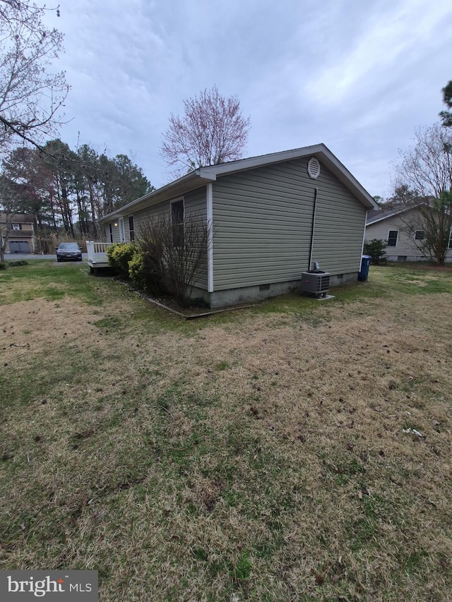 view of property exterior featuring central air condition unit, crawl space, and a lawn