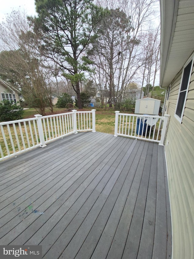 deck featuring a lawn, a shed, and an outdoor structure