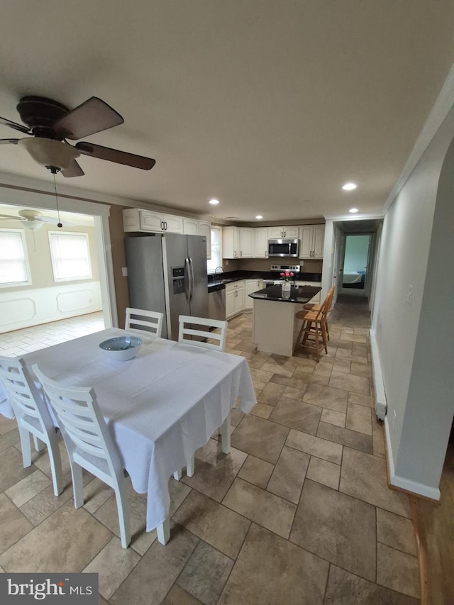 dining space featuring baseboards, crown molding, ceiling fan, and recessed lighting