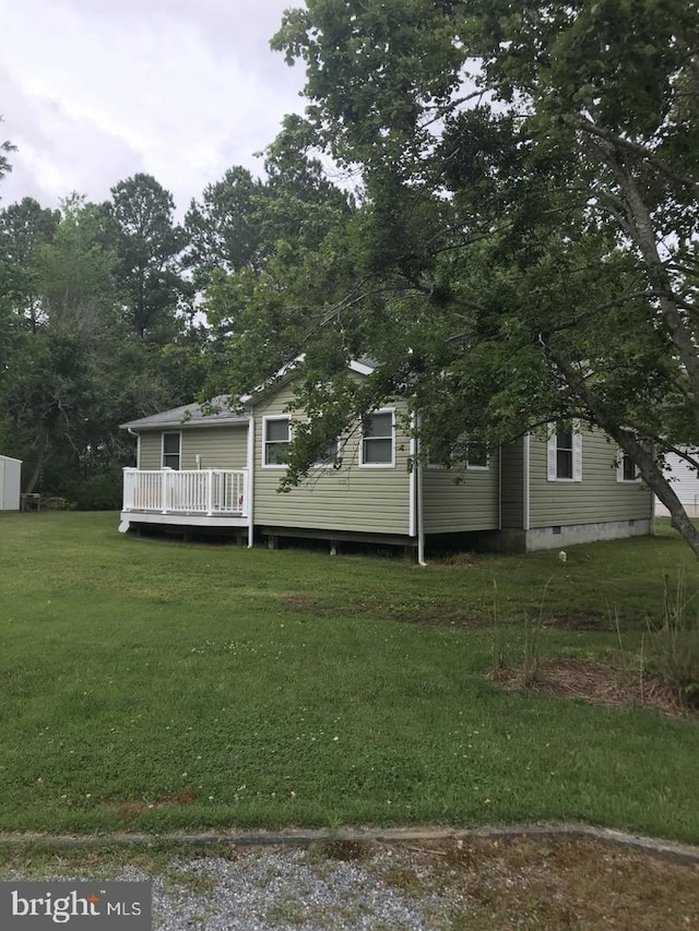 view of front of home featuring crawl space, a deck, and a front lawn