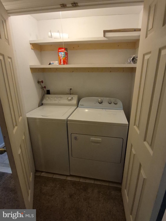 washroom with washer and clothes dryer, laundry area, and dark tile patterned flooring