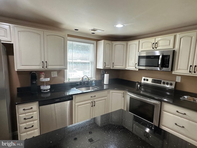 kitchen featuring recessed lighting, visible vents, appliances with stainless steel finishes, a sink, and dark stone counters