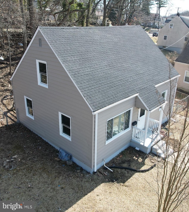 view of side of property featuring roof with shingles