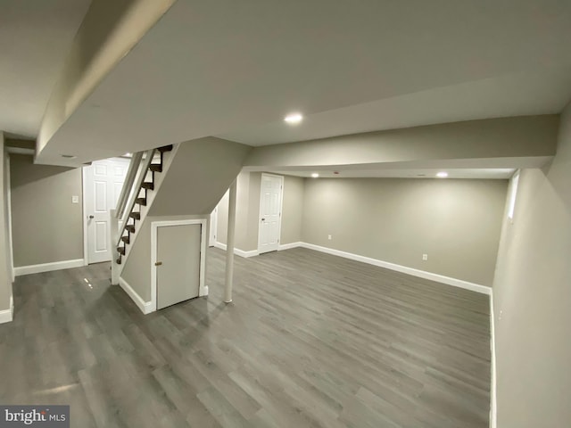 finished below grade area with recessed lighting, stairway, baseboards, and wood finished floors