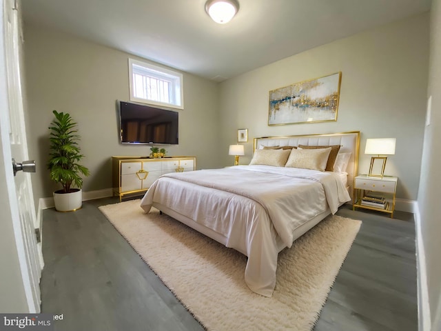 bedroom with baseboards and wood finished floors