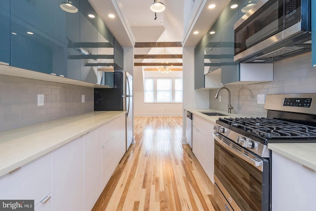 kitchen with open shelves, stainless steel appliances, light wood-style floors, a sink, and modern cabinets