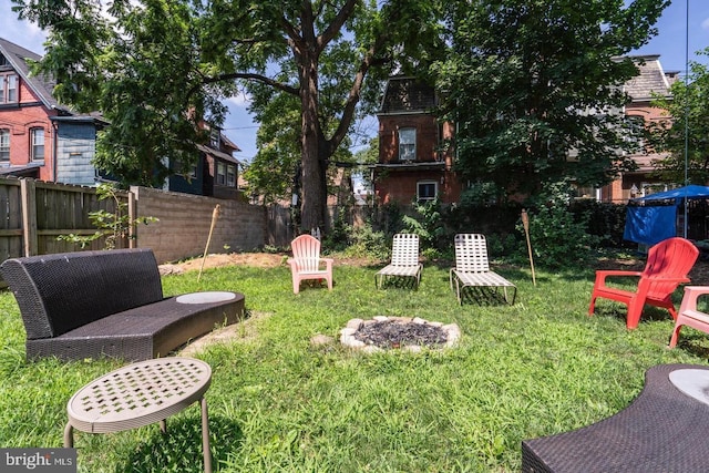 view of yard featuring an outdoor fire pit and fence