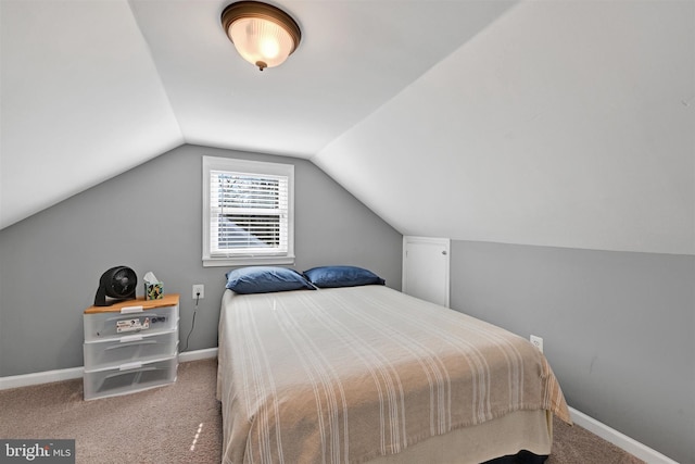 carpeted bedroom featuring lofted ceiling and baseboards