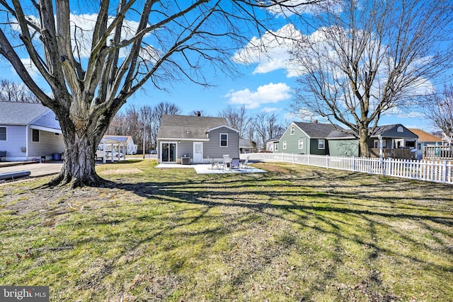 view of yard with a patio, fence, and a residential view