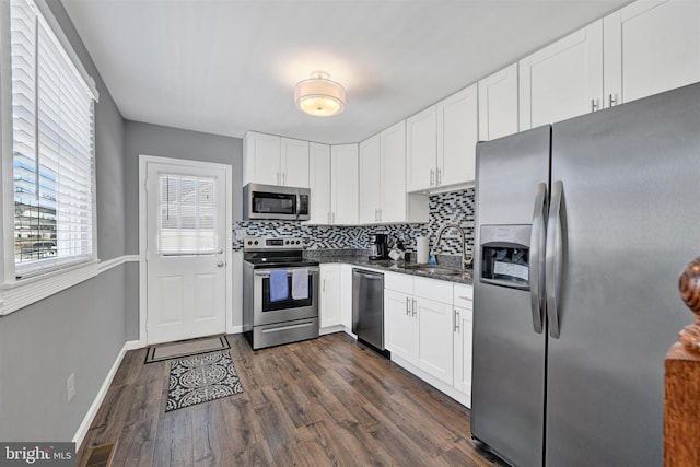 kitchen featuring visible vents, a sink, backsplash, dark wood finished floors, and appliances with stainless steel finishes