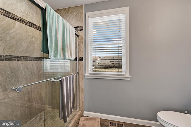 bathroom featuring visible vents, a stall shower, toilet, and baseboards