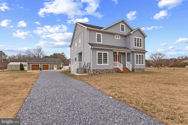 traditional-style house featuring an outbuilding, a front lawn, a garage, and central air condition unit