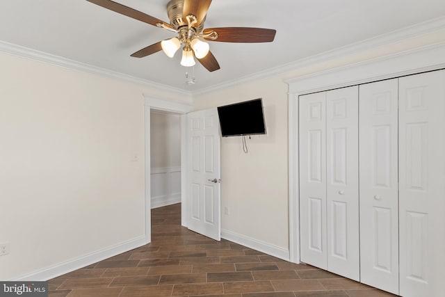 unfurnished bedroom with baseboards, ornamental molding, a closet, and wood finish floors