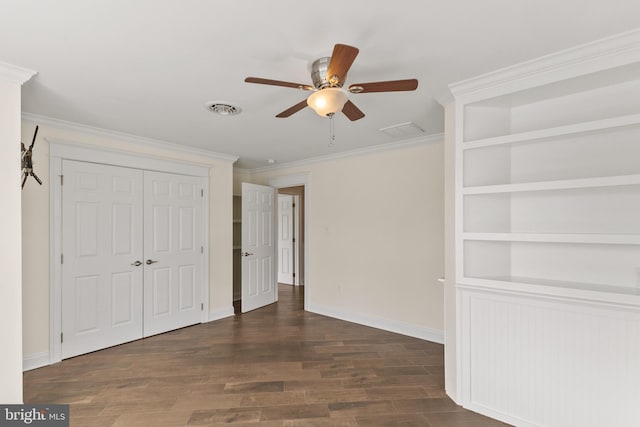 unfurnished bedroom featuring ceiling fan, visible vents, baseboards, dark wood-style floors, and crown molding