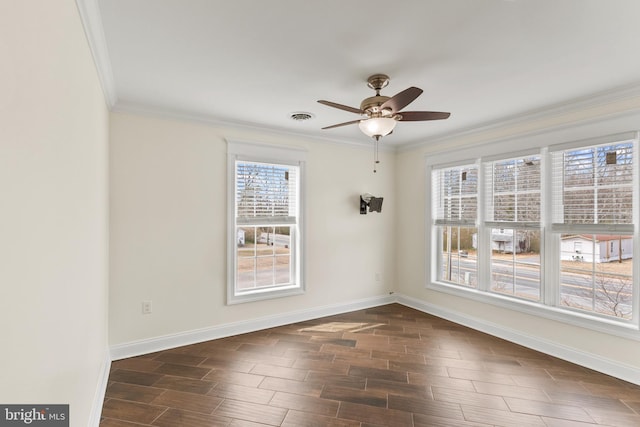 empty room featuring wood finish floors, a ceiling fan, visible vents, baseboards, and ornamental molding