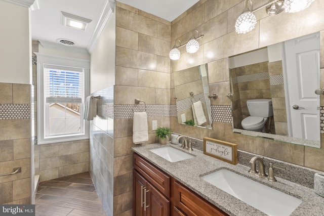 bathroom with visible vents, toilet, a sink, and tile walls