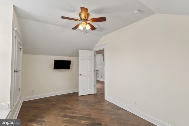 unfurnished bedroom with a ceiling fan, lofted ceiling, dark wood finished floors, and baseboards