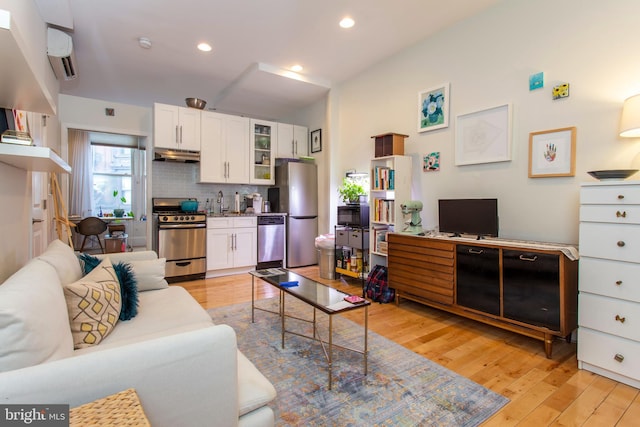 living area with light wood-style flooring and recessed lighting