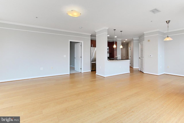 unfurnished living room with a sink, light wood-type flooring, baseboards, and ornamental molding