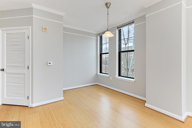 unfurnished dining area featuring baseboards, wood finished floors, and ornamental molding