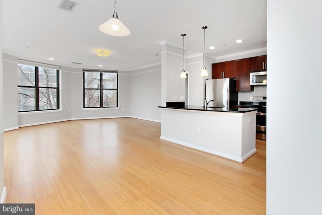 kitchen with visible vents, stainless steel appliances, light wood-style floors, dark countertops, and decorative light fixtures