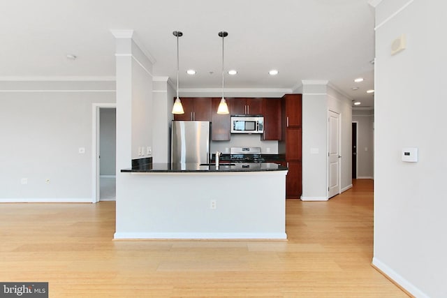 kitchen featuring a sink, dark countertops, appliances with stainless steel finishes, and light wood-style flooring