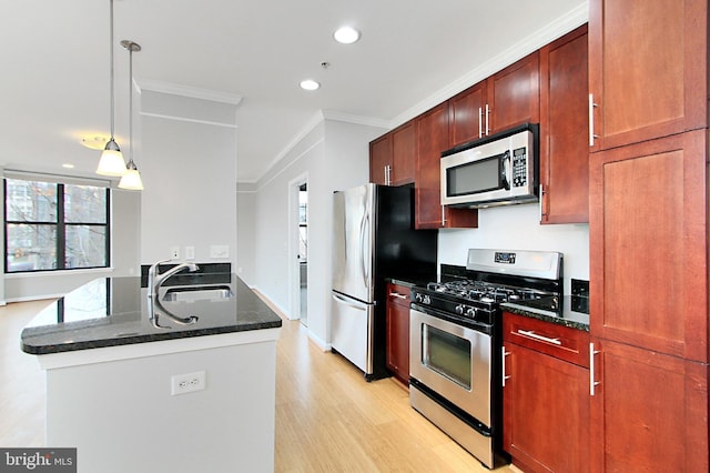 kitchen featuring a peninsula, dark stone counters, a sink, stainless steel appliances, and crown molding