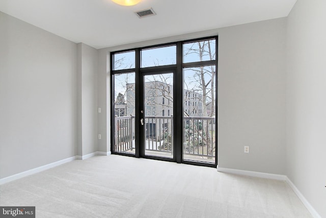 carpeted empty room with baseboards and visible vents