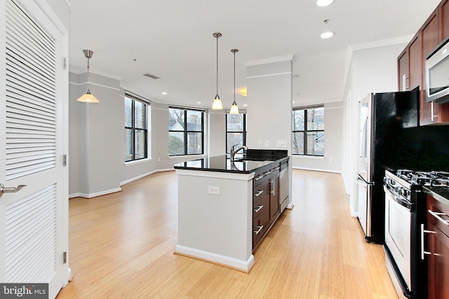 kitchen with dark countertops, stainless steel range with gas stovetop, a sink, and ornamental molding