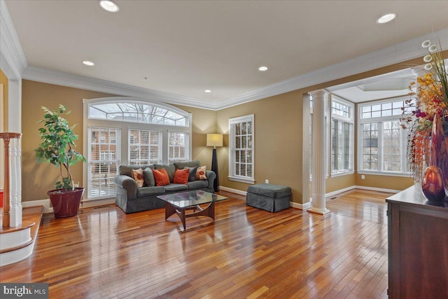 living room featuring decorative columns, baseboards, and hardwood / wood-style floors